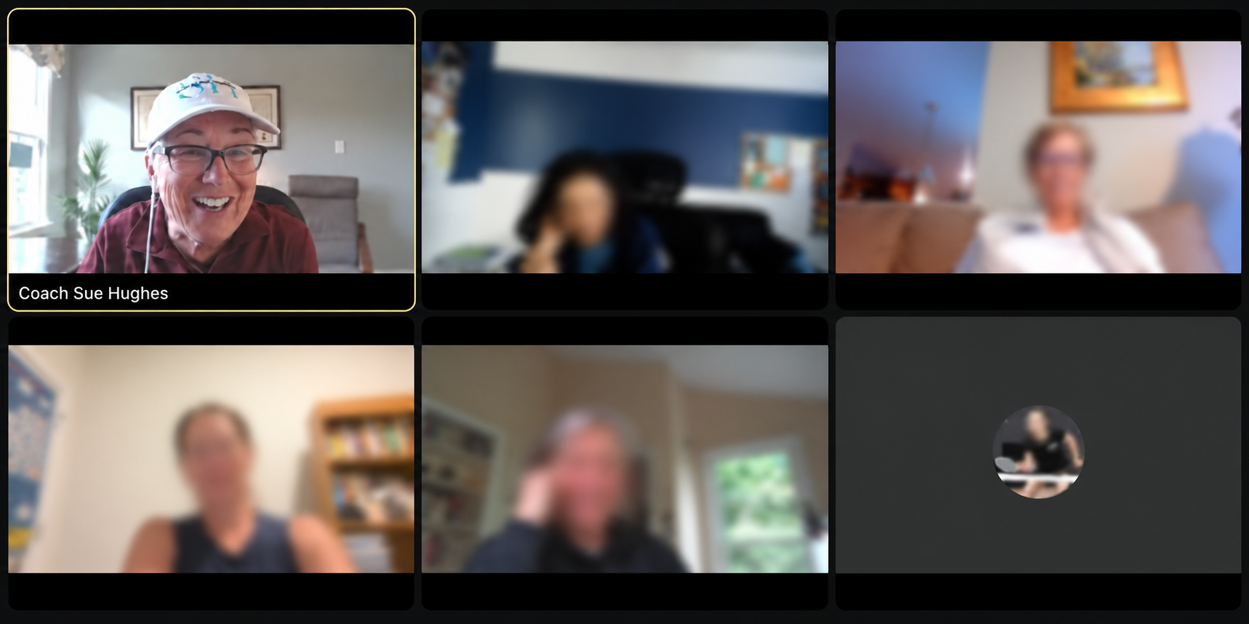 Coach Sue smiling during an online group coaching call, with other participants softened for privacy